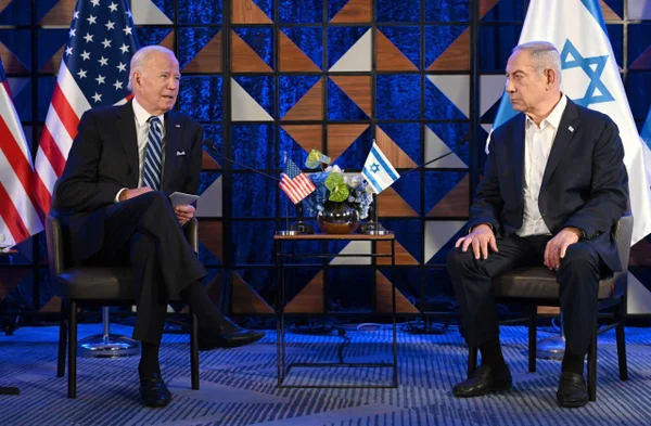 Imagem colorida mostra Joe Biden e Benjamin Netanyahu sentados com as bandeiras dos EUA e Israel ao fundo - Metrópoles
