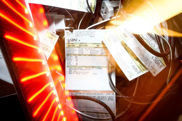 Imagem colorida mostra uma conta de luz iluminada por lâmpadas - Metrópoles