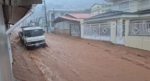 Imagem de rua alagada por chuva; um caminhão está estacionado, à esquerda - Metrópoles