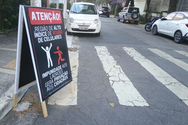 Imagem colorida mostra placa colocada na região do Parque do Ibirapuera com alerta para roubos - Metrópoles