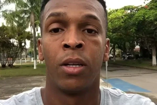Jô, homem negro com camisa cinza, olha para câmera com boca entreaberta - Metrópoles