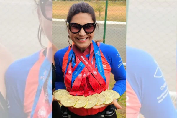 Foto colorida de mulher segurando medalhas - Metrópoles