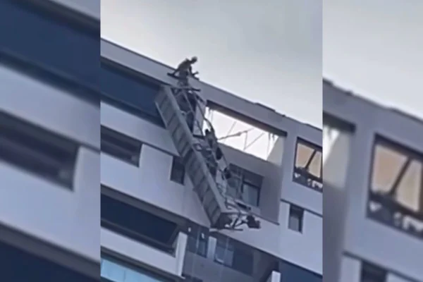 Foto colorida de trabalhadores suspensos após o rompimento de andaime, no Rio de Janeiro - Metrópoles