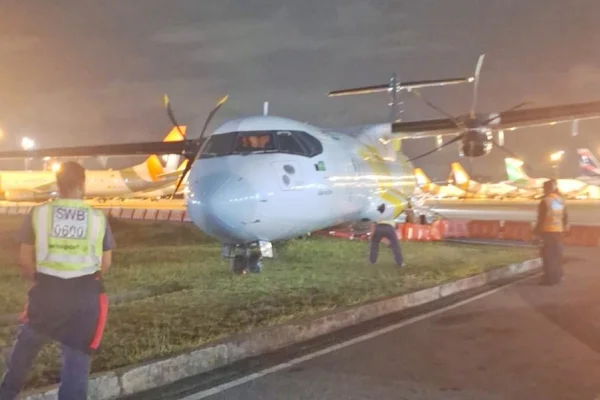 Imagem colorida de avião em cima da grama. Metrópoles