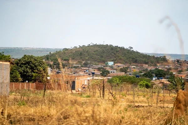 Área descampada com casas ao fundo