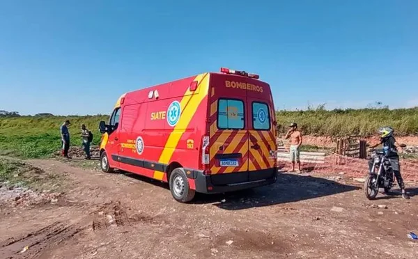 imagem colorida de ambulância vermelha parada em área de terra batida - Metrópoles