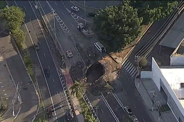 Imagem aérea colorida mostra um buraco de grandes dimensões no meio de uma pista de concreto - Metrópoles