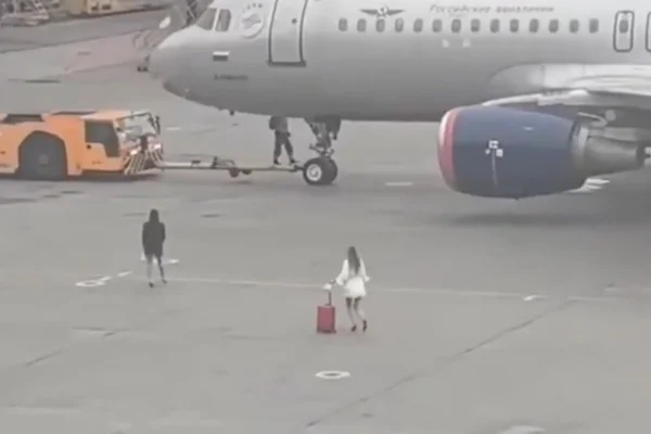 Imagem colorida mostra duas passageiras em pista de aeroporto na Rússia - Metrópoles
