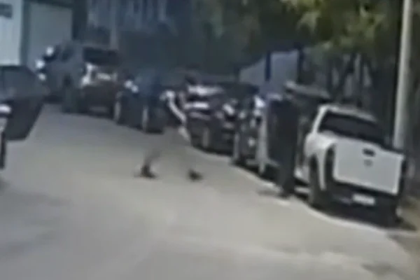Imagem colorida de dois homens, sendo um armado e o outro o empresário morto, andando por uma rua em Guarulhos - Metrópoles