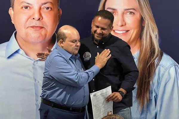 Fotografia colorida de dois homens de azul se abraçando
