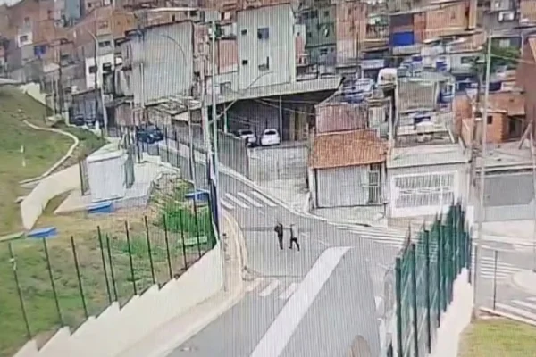 Imagem colorida de homens andando em rua. Metrópoles
