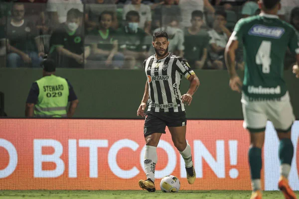 O jogador do Atlético Mineiro, Hulk, avança com a bola no campo durante jogo. Ao fundo é possível ver a torcida - Metrópoles