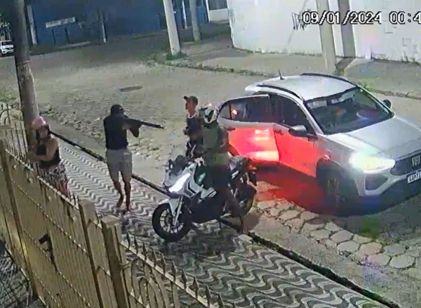 Imagem colorida mostra ladrões usando fuzil para roubar moto em São Vicente