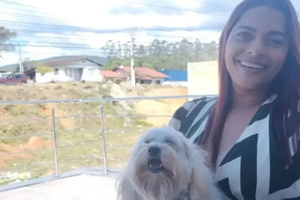 Imagem colorida de mulher segurando cachorro