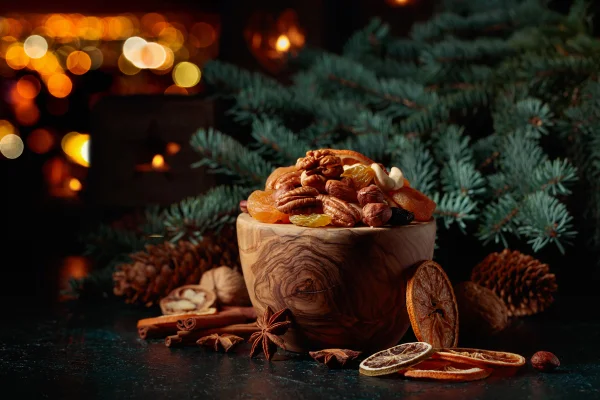 Decoração de Natal com frutas secas, nozes, ramos de abeto e velas acesas em um fundo de cidade noturna. Copie o espaço. Nozes frutos natalinos