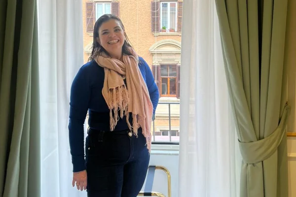 Foto colorida de mulher com vestes pretas, sorrindo e posando para foto - Metrópoles