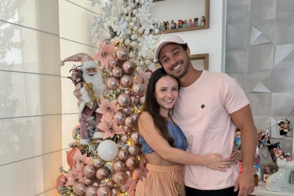 Foto colorida de Larissa Manoela e André Luiz Frambach posando em frente a árvore de Natal - Metrópoles