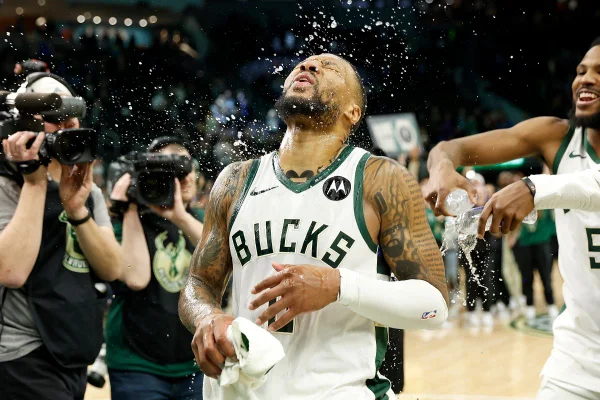 Damian Lillard nº 0 do Milwaukee Bucks reage após receber água derramada sobre ele, comemorando sua chance de vitória contra o Sacramento Kings
