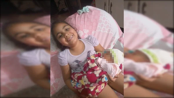 menina sorrindo com bebê no colo