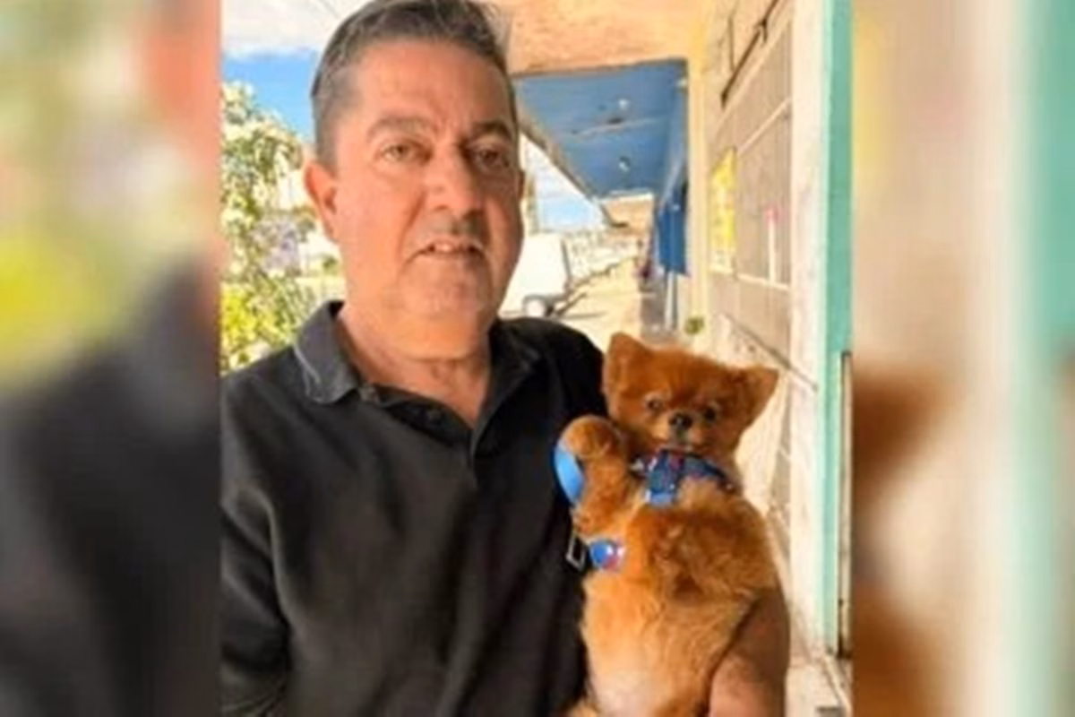 Imagem de homem segurando um cachorrinho