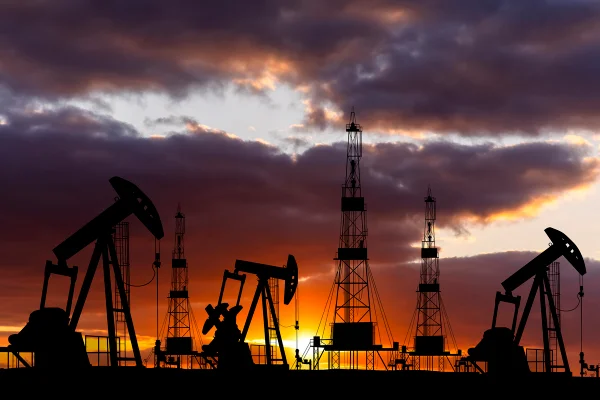 Campo petrolífero com plataformas ao pôr do sol. Indústria petrolífera mundial - Metrópoles