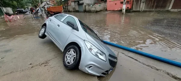Imagem colorida de Após chuva, carro é engolido por buraco