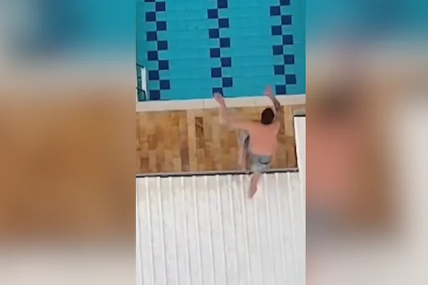 Imagem colorida de homem pulando de telhado para fugir de policiais. Metrópoles