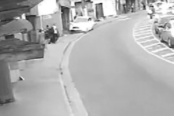Imagem em preto e branco mostra carro em cima de calçada. Motorista que dirigia o veículo teve mal súbito - Metrópoles