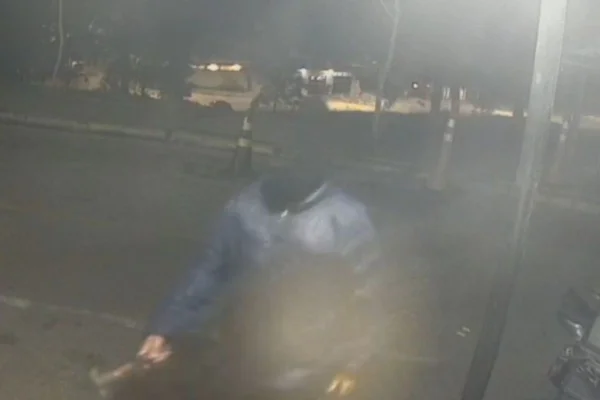 Foto colorida de vídeo em que mostra homem mascarado com martelo atingindo portaria de condomínio, em Cotia, região metropolitana de São Paulo.