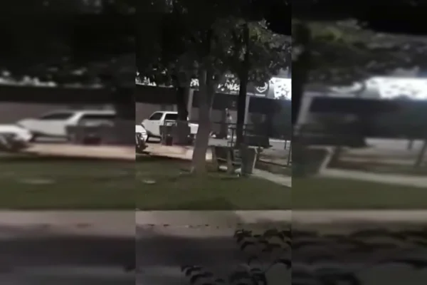 Homem vestindo camisa branca ataca outro homem, com faca, em estacionamento de comércio