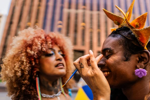 Foliões passando maquiagem em bloquinho de Carnaval - Metrópoles