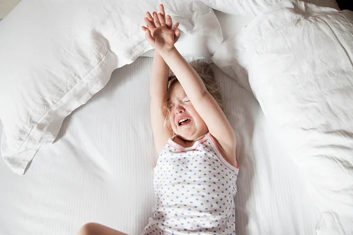 menina chorando na cama