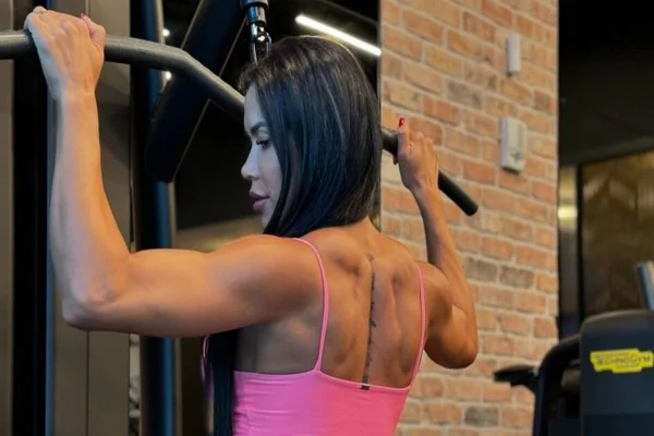 Imagem colorida, mulher fazendo exercícios na academia - Metrópoles