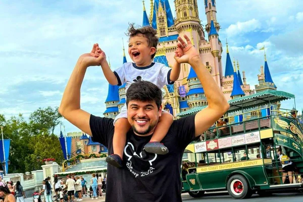 foto colorida de cristiano com o filho miguel nos ombros em parque da disney - metrópoles