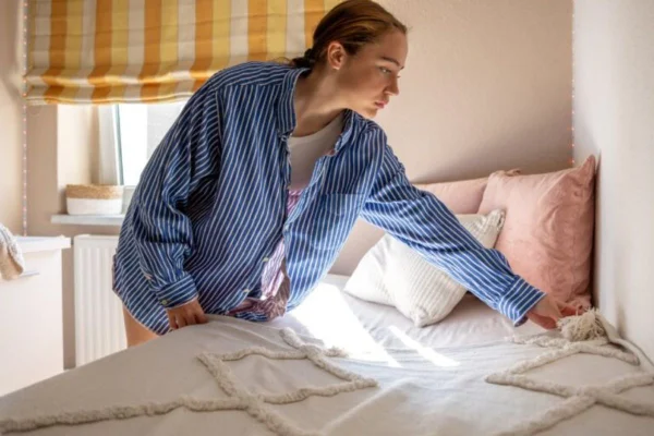 mulher arrumando a cama