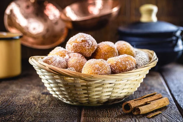 Bolinho de chuva açucarado dentro de um cesto - metrópoles
