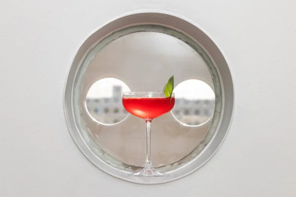 Drinque avermelhado em taça coupe