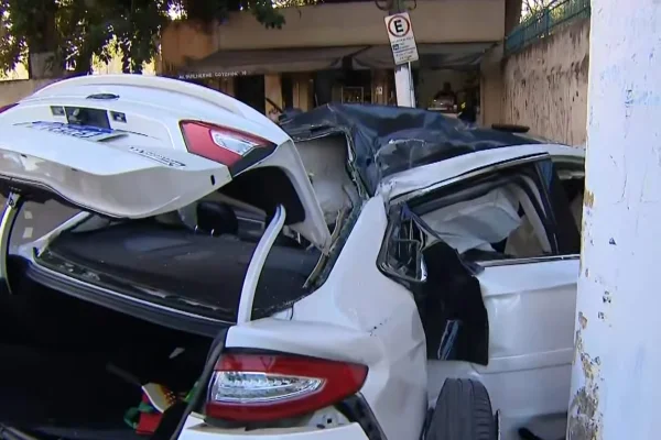 Imagem colorida de um carro branco destruído após colisão