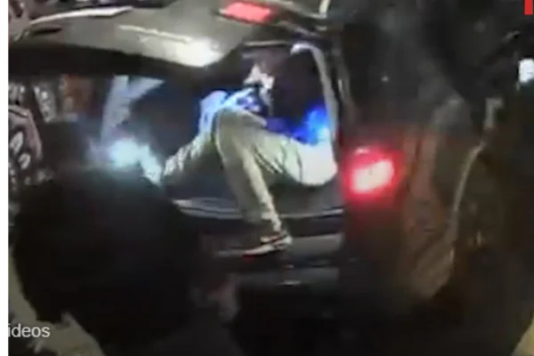 Homem sendo colocado em traseira de SUV - Metrópoles