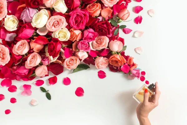 foto colorida de pessoa espirrando perfume em flores da primavera