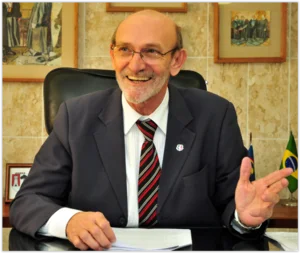 desembargador Bartolomeu Bueno sentado em seu gabinete acenando com gravata vermelha listrada / Metrópoles