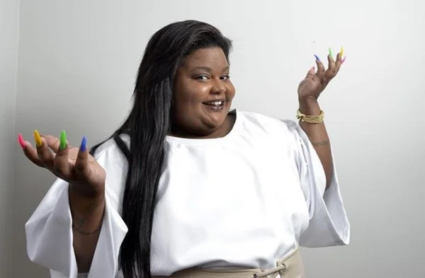 mulher gorda preta de cabelo longo liso vestida com blusa branca - metrópoles