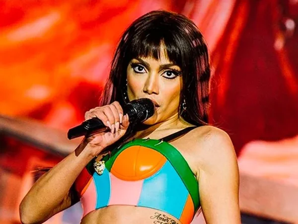 A cantora Anitta segura microfone e canta em festival na Europa, usando peruca lisa e cropped colorido - Metrópoles