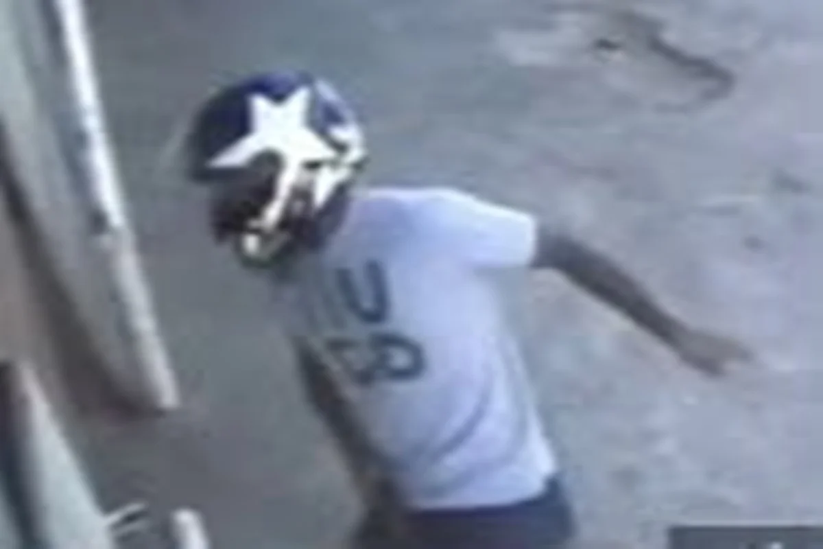 O homem estava de calça jeans azul, camisa cinza, e um capacete azul com uma estrela branca O homem estava de calça jeans azul, camisa cinza, e um capacete azul com uma estrela branca