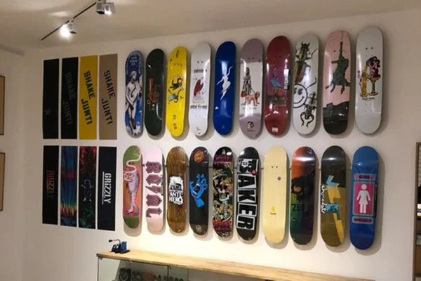 Imagem colorida contendo skates na parede