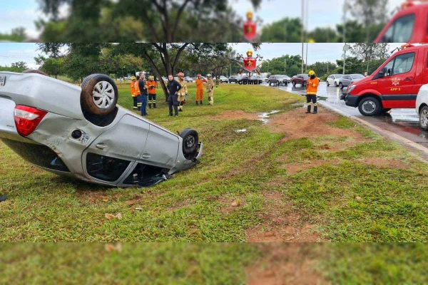 Carro prata capotado na EPIA Norte em gramado, cercado por veículo e profissionais dos Bombeiros do DF - Metrópoles