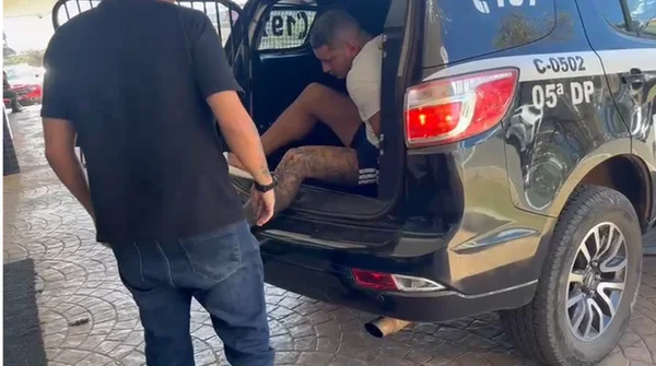 Homem preso descendo de camburão