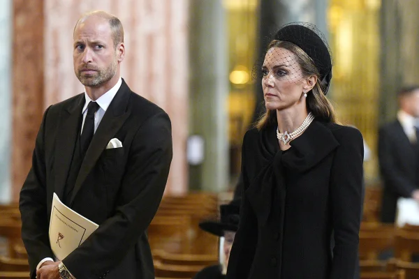 Foto colorida de homem com terno preto ao lado de mulher com roupa preta - Metrópoles
