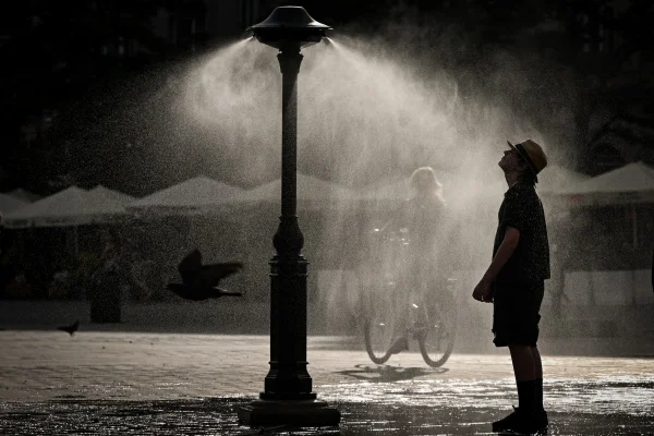 Um homem se refresca na Praça do Mercado de Cracóvia, Polônia