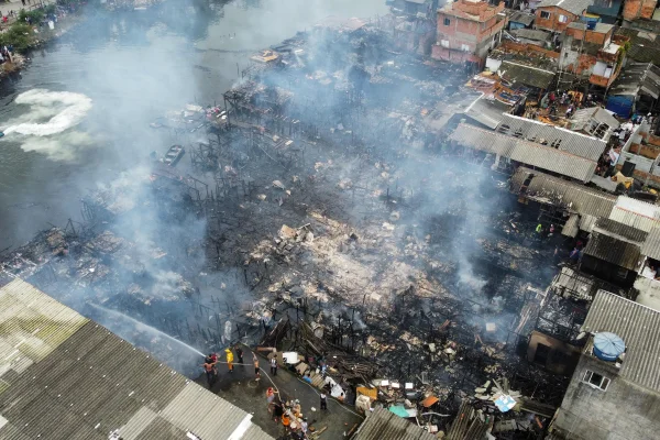 Imagem colorida de comunidade pegando fogo em Santos. Metrópoles